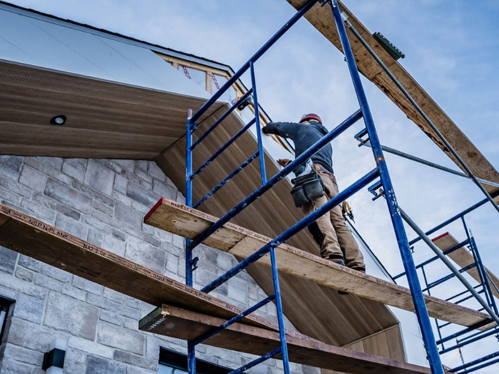 Pose de l'enveloppe extérieure et isolation haute performance sur un chantier REOVA.