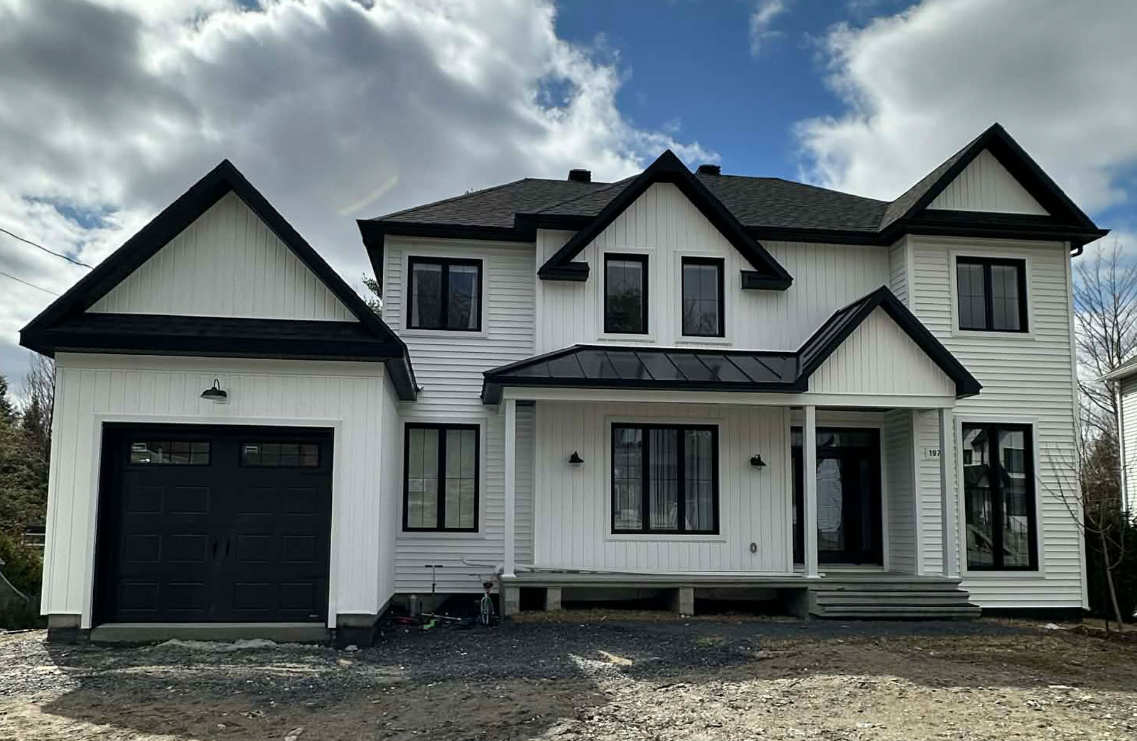 Construction d'une maison unifamiliale moderne de style farmhouse contemporain par REOVA en Estrie.
