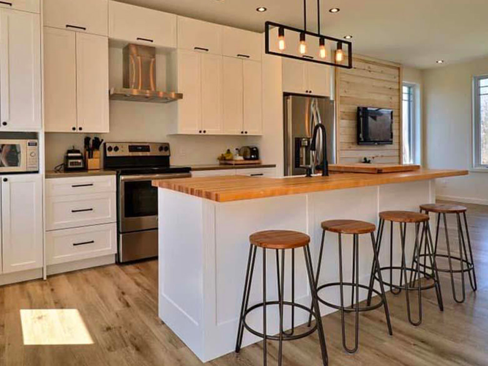 Rénovation de cuisine moderne avec îlot central et luminaires suspendus.